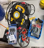 Overview photo showing wire brush set, PowerGlow portable LED work light, shackles, clamps, cords, and maintenance kit in blue plastic bin