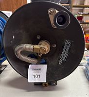 Close-up front view of black Campbell Hausfeld air hose reel showing label and connection fitting.