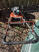 Handlebar view wrapped in black tape, showing wear and tear, part of the mower's operator controls.
