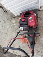 Red Craftsman lawnmower showing from above with red handle, gasoline tank, and engine components visible