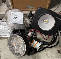 Lot showing two vehicle lights and one portable LED work light with cables