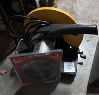 Side view of abrasive cutoff machine with yellow protective cover and Benchmark saw blade in packaging in front.