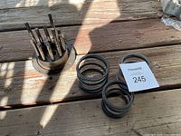 Photo of motorcycle clutch hub with bolts and three metal coil springs on wooden surface.