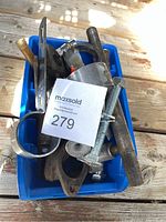 Blue plastic bin containing assorted bolts, screws, gasket, and fasteners on wood surface