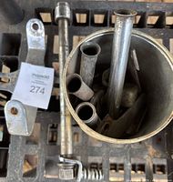 Top view of the dual headlight mount bracket, quick release skewer, and tin container with metal tubes.