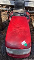 Front view of red Craftsman YT3000 riding lawnmower with black seat and some dirt on the body.