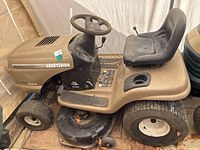 Side view of mower showing body, steering wheel, seat and mower deck