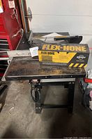 Rockwell table saw showing the top surface with blade guard and Flex-Hone box placed on top