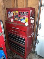 Front view of two-piece red metal tool chest showing stickers and drawer configuration