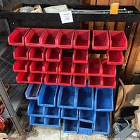Tool organizer with 40 plastic bins, red and blue, on a black metal frame.
