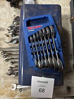 Top view of blue metal toolbox with Westward wrench set in blue plastic holder and additional metal wrenches scattered around.