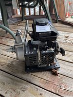 Side view of Power Fist water transfer pump showing gas tank, pull starter, and hose connection.