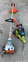 Both Stihl trimmer and Poulan chainsaw side by side on concrete