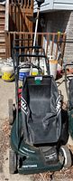 Craftsman push lawn mower with grass collection bag, shown from the front outside on pavement and leaves