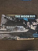 Top view of original box showing The Moon Bus on lunar surface, branding, and movie association.