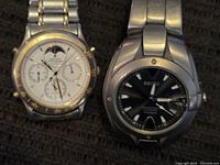 Two Seiko men's watches side by side on fabric background, showing dial details and metal bands.