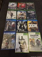 Photo showing 13 sealed video games for Xbox 360, Xbox One, and PS4 spanning genres including sports, shooter, and adventure.