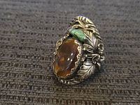 Front angled view showing agate and turquoise stones with detailed silver leaf and floral pattern on ring.