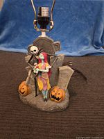 Full view of The Nightmare Before Christmas lamp with Jack and Sally figurines, pumpkins and tombstones