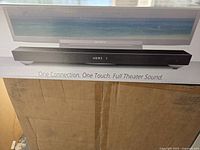 Box front showing image of soundbar with TV, Sony branding, and model HT-XT1.