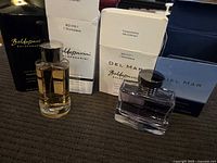 Two bottles of Baldessarini Eau de Cologne Concentrée with packaging shown, one clear and one blue bottle.