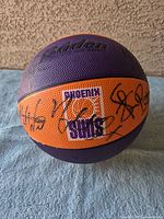 Front side showing the Phoenix Suns basketball with multiple autographs in black ink and the team logo.