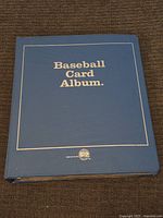 Blue hardcover Baseball Card Album labeled 'Baseball Card Album' containing vintage cards under plastic sleeves.