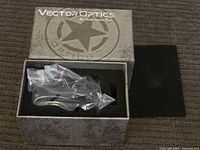 Vector Optics branded box with riflescope inside protective plastic and foam insert.