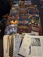 Top view showing an assortment of vintage RPG books, mainly Advanced Dungeons & Dragons and Pathfinder titles.