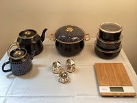 Full view of the Schafer Glaze enameled cookware set including kettles, pot, food containers, spice shakers, and digital scale on a table