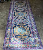 Full-length view of runner rug on concrete floor showing overall pattern and condition