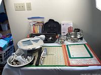 Photo of baking supplies laid out on table showing pie pans, cake pans, decorating tools and accessories.