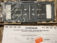 Packaged Echogear full motion TV wall mount hardware wrapped in plastic in original box with drilling template labeled Echogear.