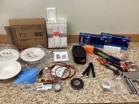 Overview of electrical supplies including switches in box, retrofit downlights, clamps, tape, and various tools