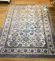 Top view of the full rug showing the overall pattern and color scheme of blue and gray in a floral and geometric design.