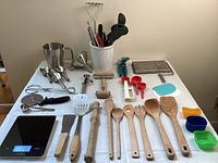 Overall view of kitchen utensils, measuring spoons, silicone molds, and Koios digital scale arranged on table