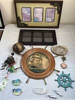 Photo showing all items including framed maps, ship wheel wall art, ceramic birds, shell dish, stones, and decorative ornaments.
