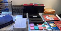 Wide view of the lot showing file storage boxes, metal organizer, document locking bag, sticky notes, labels and envelopes