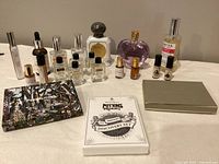 Lot of perfumes and colognes displayed together on a flat surface including boxed sample sets and various small bottles, mostly from Demeter and Penhaligon.