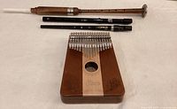 Photo showing the Eison kalimba, the two plastic flutes, and the wooden and metal flute