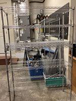 Front view of large metal wire shelving unit showing five wire grid shelves and structural metal poles in garage or basement space.