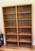 Front view of oak bookshelf showing full height and width with evenly spaced shelves.