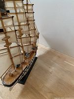 Close-up photo of detailed wooden ship model America Vespucci with rigging, sails, and wooden deck.