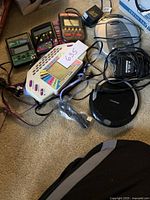 Photo showing the entire lot with the Sylvania CD player, silver AM/FM CD player, and several handheld electronic games.