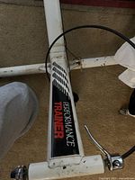 Close-up photo of the white metal frame labeled 'Performance Trainer' with visible scratches and scuffs.