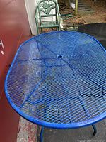 Blue metal mesh oval outdoor table shown from above