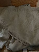 Pale green fabric curtains folded, showing soft material and size