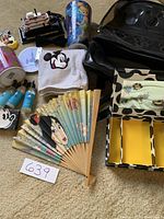 Full lot content showing backpack, fan, towel, jewelry box, toiletries, mug, and Liberty Belle miniature.