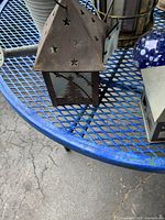 Close-up of a metal lantern showing star motifs and cutout tree design on glass panel