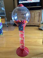 Full view of 3 foot tall gumball machine showing colorful gumballs in clear globe, red spiral dispenser tube, and base.